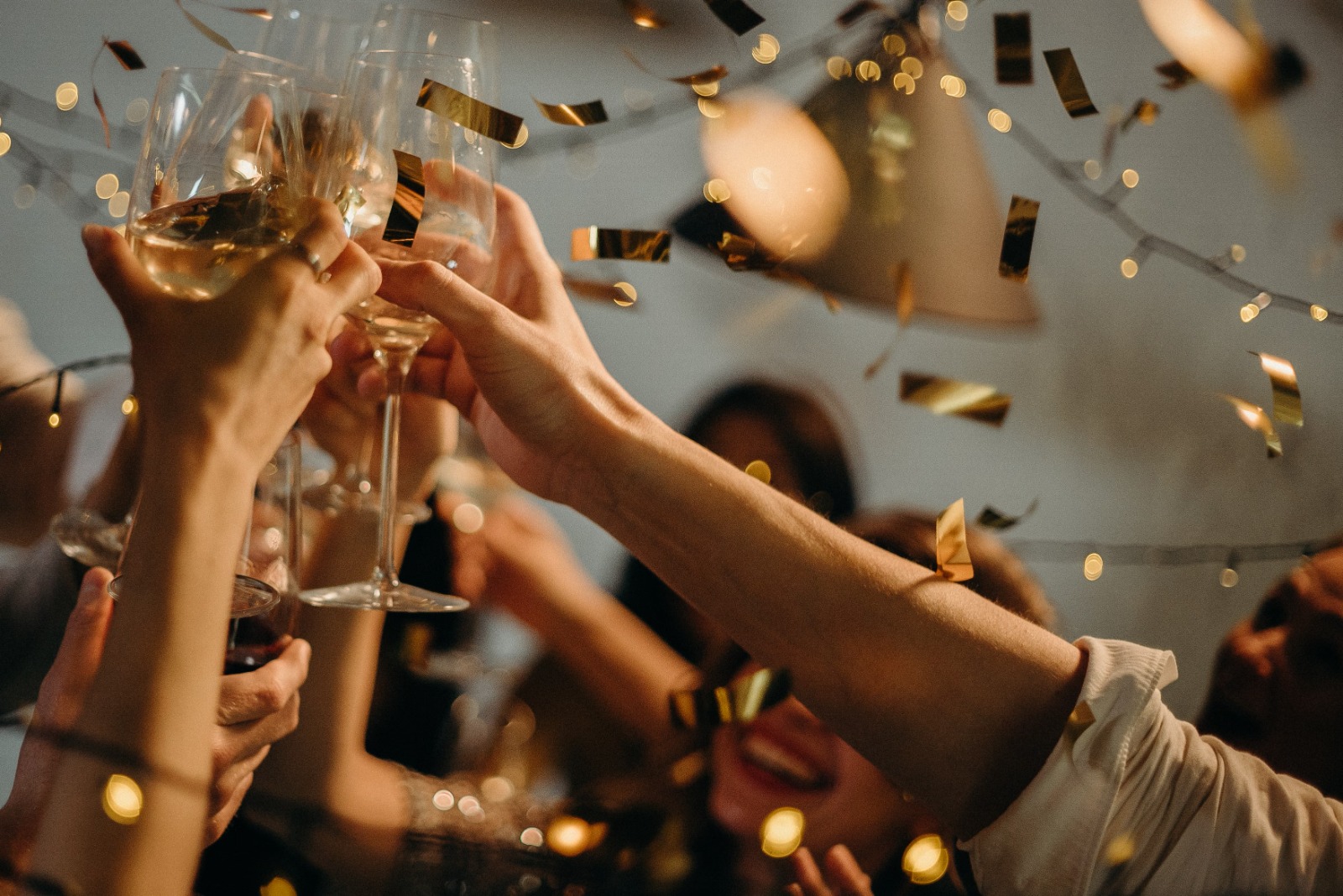 Un brindisi tra amici con calici e coriandoli dorati per festeggiare un’occasione speciale